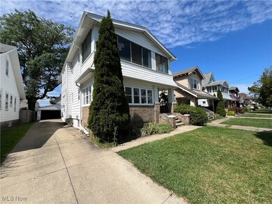 View of front of house featuring a garage, an outdoor structure, and a front yard