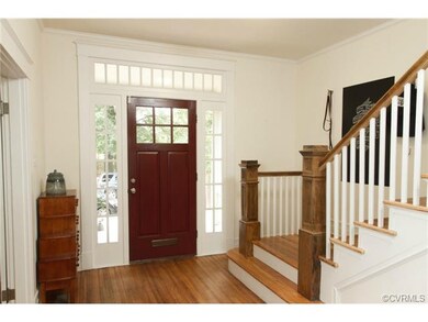 The Foyer boasts refinished hardwood floors, crown moulding, & an open staircase with wooden spindles.