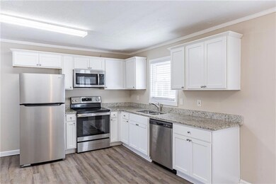 Kitchen featuring white cabinetry, sink, light woo