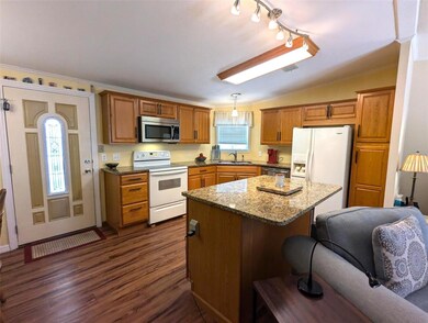 Enter into this custom upgraded Kitchen w. nice cabinets, granite countertops and center island w/counter seating.