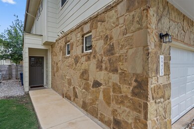 Doorway to property with stone siding and a garage