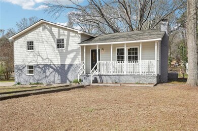 Split level home featuring a front yard, covered p