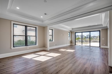 Empty room featuring a tray ceiling, visible vents
