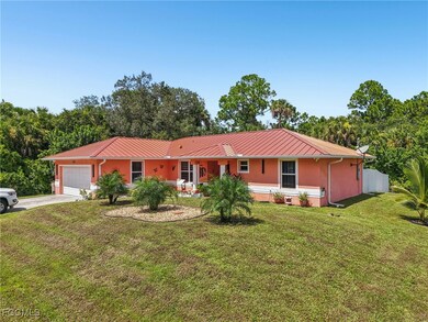 Ranch-style home with concrete driveway, a metal roof, an attached garage, and a front yard