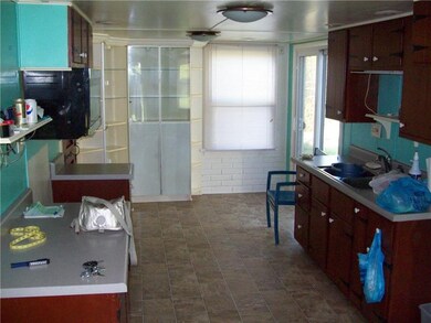 OTHER VIEW OF KITCHEN WITH SINK AND WOOD CABINETS