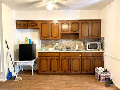 Kitchen with sink, backsplash, ceiling fan, and li