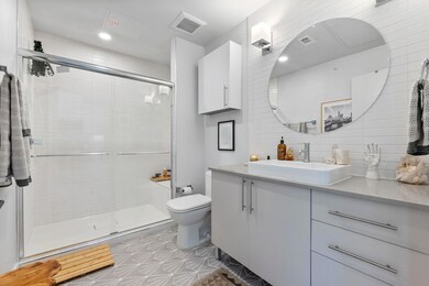 Bathroom featuring vanity, a shower stall, tastef