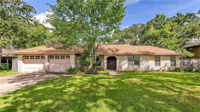 Ranch-style house featuring brick siding, an attac
