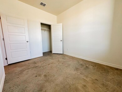 Unfurnished bedroom with unfinished concrete flooring and a closet