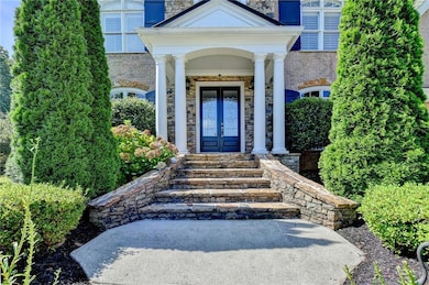 View of exterior entry featuring stone siding and french doors