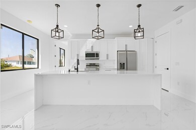 Kitchen featuring marble finish floor, appliances