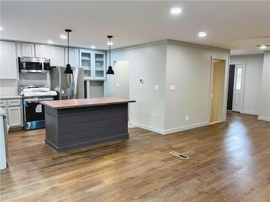 Kitchen with white cabinetry, a center island, han