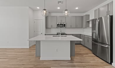 Kitchen with gray cabinets brushed satin nickel finishes