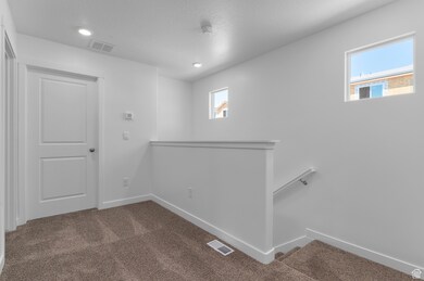 Empty room featuring dark carpet, a textured ceiling, and recessed lighting