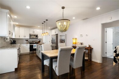 Dining space with a chandelier, recessed lighting, dark wood-style floors, ornamental molding, and baseboards