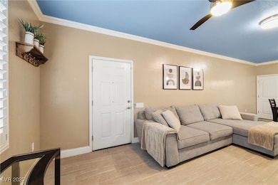 Living area with crown molding, ceiling fan, light