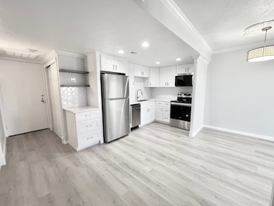 View from corner of dining area: entry, kitchen, p