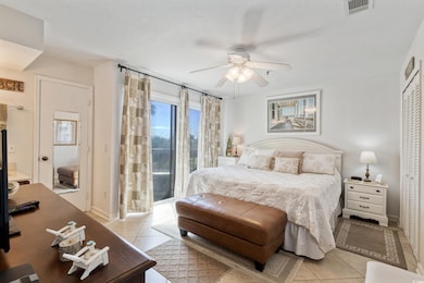 Tiled bedroom with access to private deck, ceiling fan, and a closet