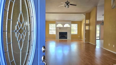 Wood finished floors, a fireplace, and a ceiling fan