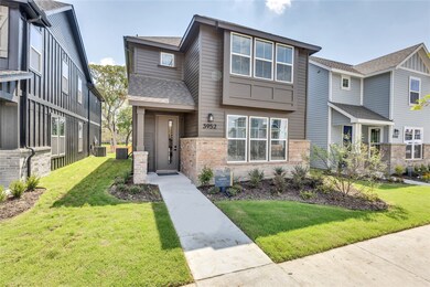 View of front of property featuring brick siding, a front lawn, and roof with shingles