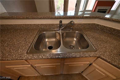 Kitchen view of a sink, dark countertops, and a ti