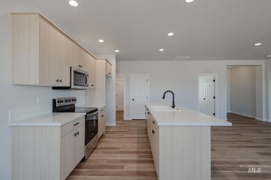 Kitchen featuring appliances with stainless steel finishes, light countertops, recessed lighting, light brown cabinetry, and light wood-type flooring
