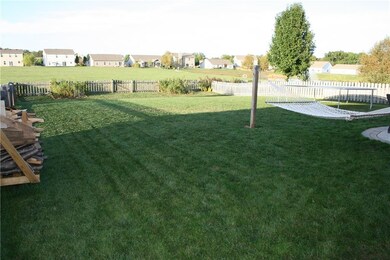 Spacious yard is fully fenced and conveniently has a gate in the middle across the back and one on each side of the house.  A pond with illuminated fountain is located behind the tree in the photo. 