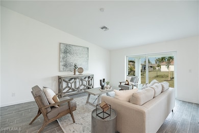 Living room featuring vaulted ceiling, baseboards,