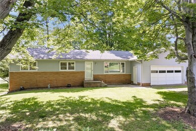 Ranch-style home featuring a front lawn and a garage