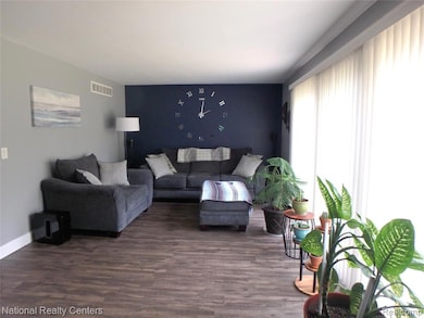 Living area with dark wood-style floors and an accent wall