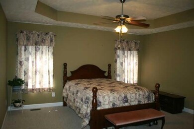 This large master suite offers a beautiful tray ceiling and a door that leads out onto the covered deck.