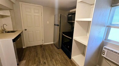 Kitchen with dark wood-style flooring, a sink, li