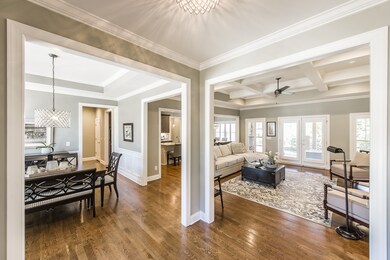 Coming in the front door you have a view of the formal dining room & living room from foyer. You'll notice the upgraded lighting and coffered ceilings!