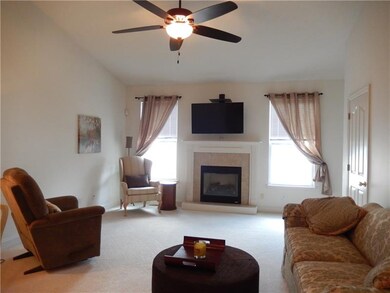 Great room boasts fireplace, ceiling fan door to a