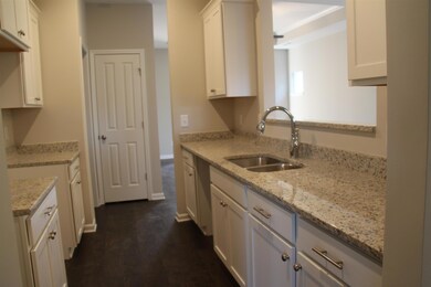 The kitchen has white cabinets and ample counter space.
