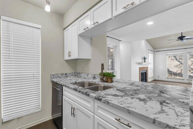Kitchen with a sink, a ceiling fan, white cabinetr