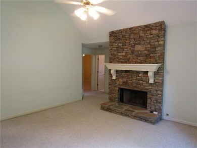 Unfurnished living room with a fireplace, a ceiling fan, carpet floors, and lofted ceiling