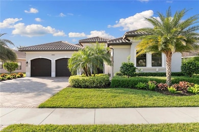 Mediterranean / spanish house featuring an attached garage, stucco siding, decorative driveway, a tile roof, and a front lawn