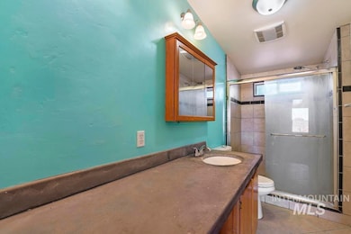 Full bath featuring vanity, a shower stall, and light tile patterned flooring
