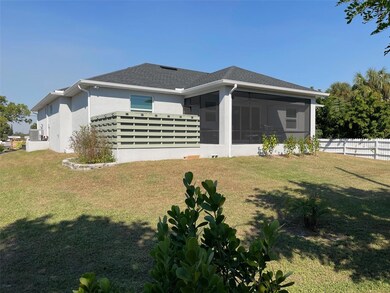 Exterior back of home showing screen lanai and yard.
