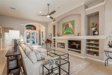 Living room featuring a fireplace, light tile patterned flooring, recessed lighting, french doors, and built in shelves