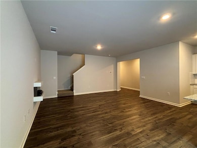 Unfurnished living room featuring stairs, dark wood-type flooring, and recessed lighting
