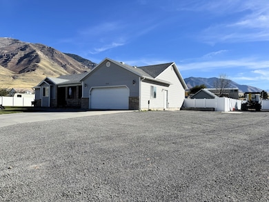 View of front of home featuring a mountain view, driveway, an attached garage, roof with shingles, and brick siding