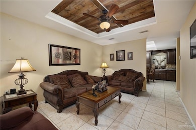 Living area featuring wooden ceiling, visible vents, a ceiling fan, and a raised ceiling