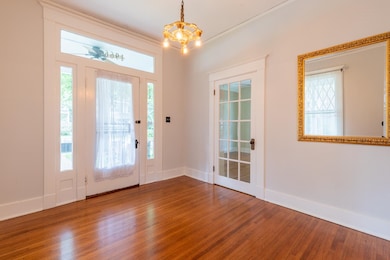 Foyer entrance featuring wood finished floors and a chandelier