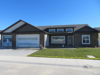 View of front of house featuring a front lawn, concrete driveway, an attached garage, and roof with shingles