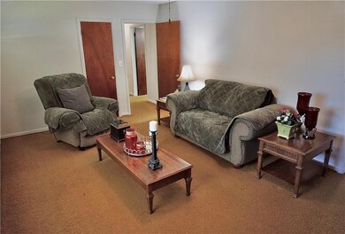 Living area featuring carpet flooring and baseboards