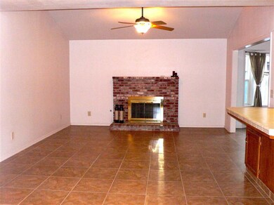 Family room with tile floor, brick fireplace, slop