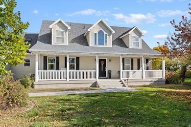 Cape cod-style house with a porch, a shingled roof, and a front yard