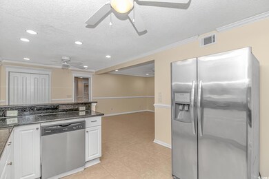 Kitchen with white cabinetry, dark stone counterto